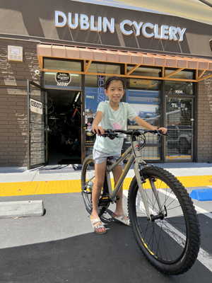 A child on a bike in front of Dublin Cyclery after being fitted for the proper sized bike.